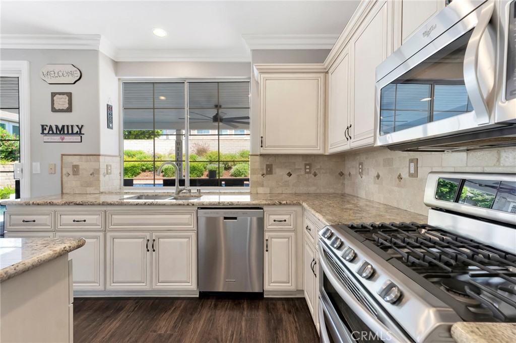 2702 Titania Place Simi Valley, CA 93063 - Photo 13 of 38 a kitchen with stainless steel appliances a stove sink and cabinets