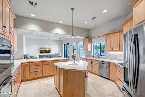 a large kitchen with stainless steel appliances a sink counter space cabinets and a large window