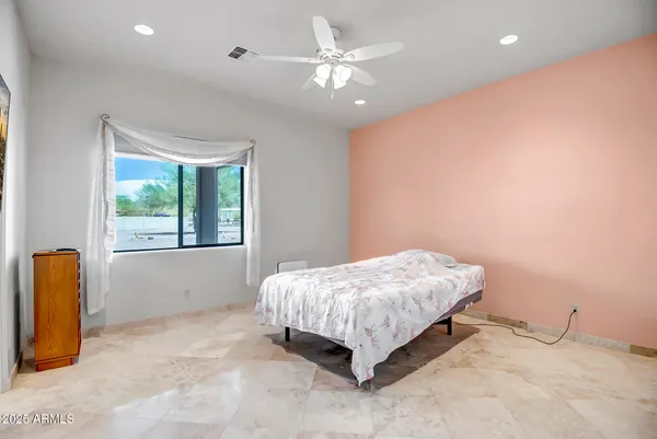 a spacious bedroom with a bed and a chandelier