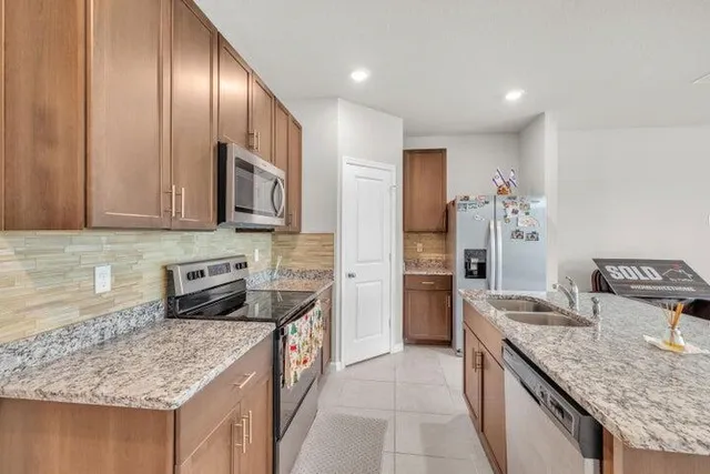 a kitchen with stainless steel appliances granite countertop a sink stove and refrigerator
