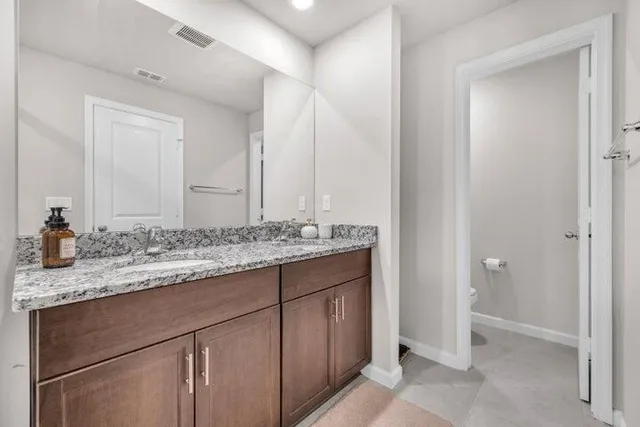 a bathroom with a granite countertop sink and a mirror