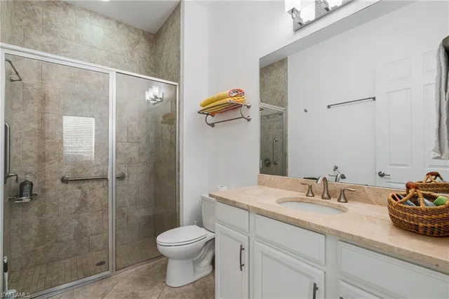 a bathroom with a granite countertop sink a toilet and shower