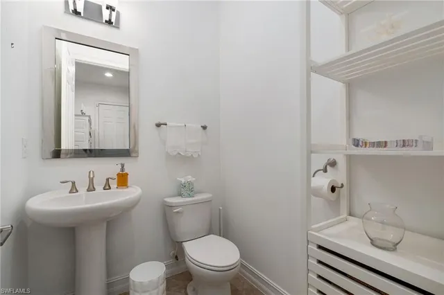 a bathroom with a sink toilet and mirror