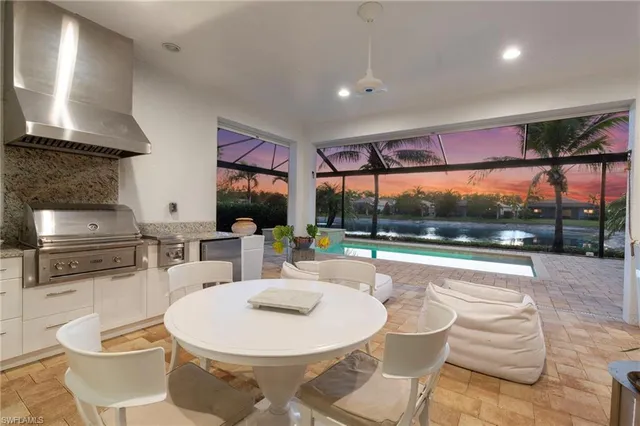 a kitchen with a stove a kitchen island a table and chairs in it