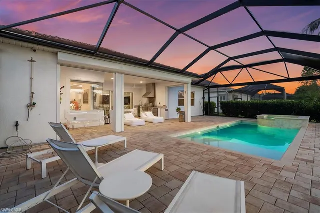 a view of a backyard with table and chairs under an umbrella