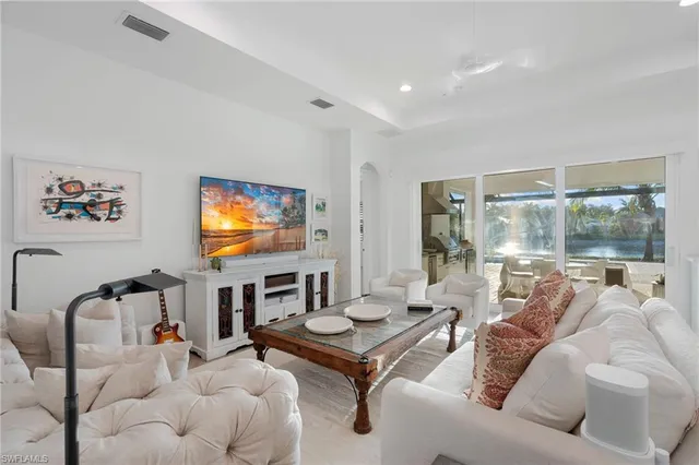 a living room with furniture a flat screen tv and a floor to ceiling window
