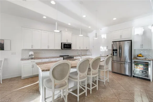 a kitchen with appliances cabinets and chair