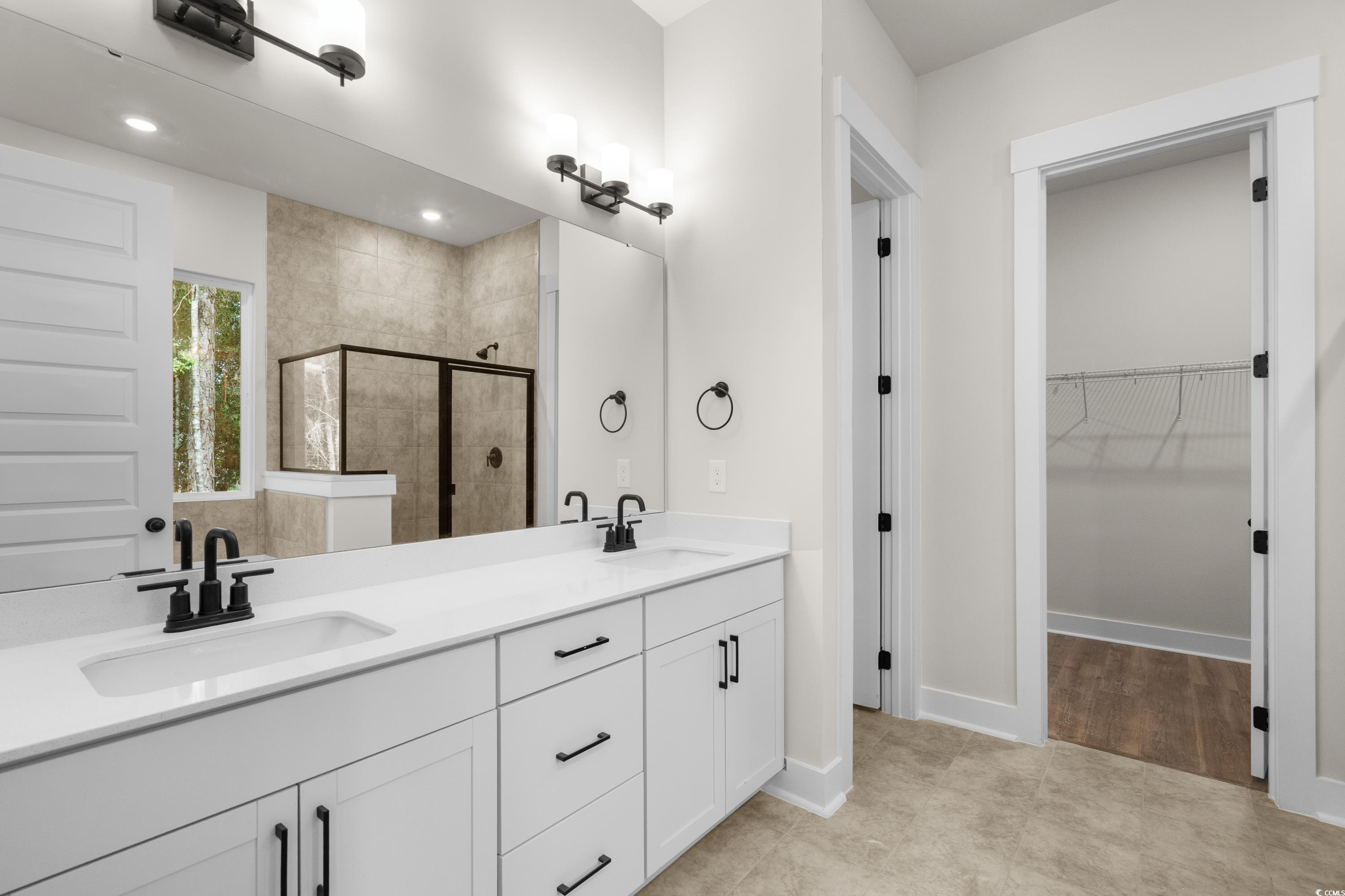 82 Bridge View Road Georgetown, SC 29440 - Photo 14 of 32 Bathroom with a shower stall, a spacious closet, double vanity, and light tile patterned floors