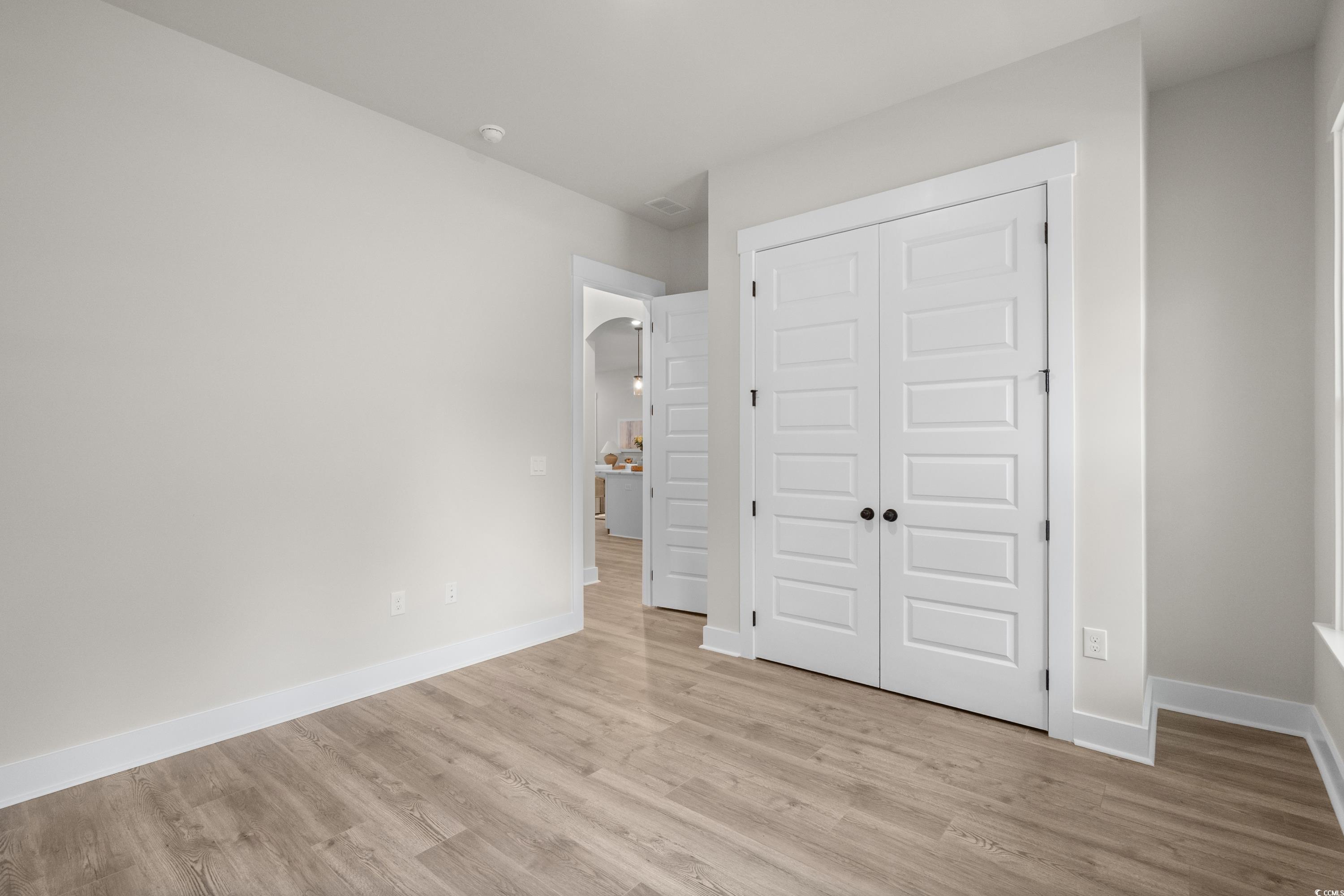 82 Bridge View Road Georgetown, SC 29440 - Photo 17 of 32 Unfurnished bedroom with arched walkways, a closet, and light wood-style flooring