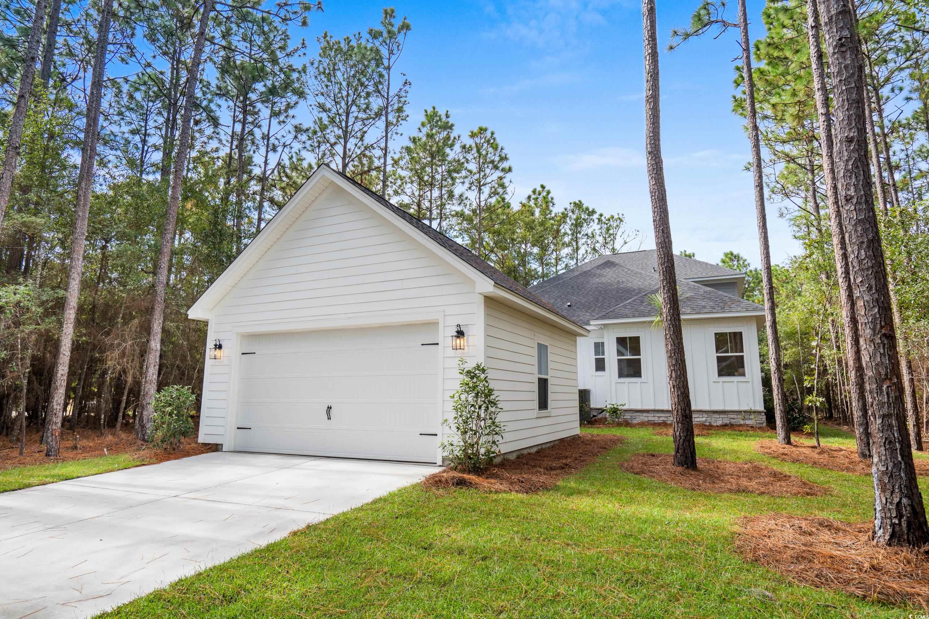 82 Bridge View Road Georgetown, SC 29440 - Photo 25 of 32 View of front of home with roof with shingles, a garage, driveway, a front yard, and an outdoor structure