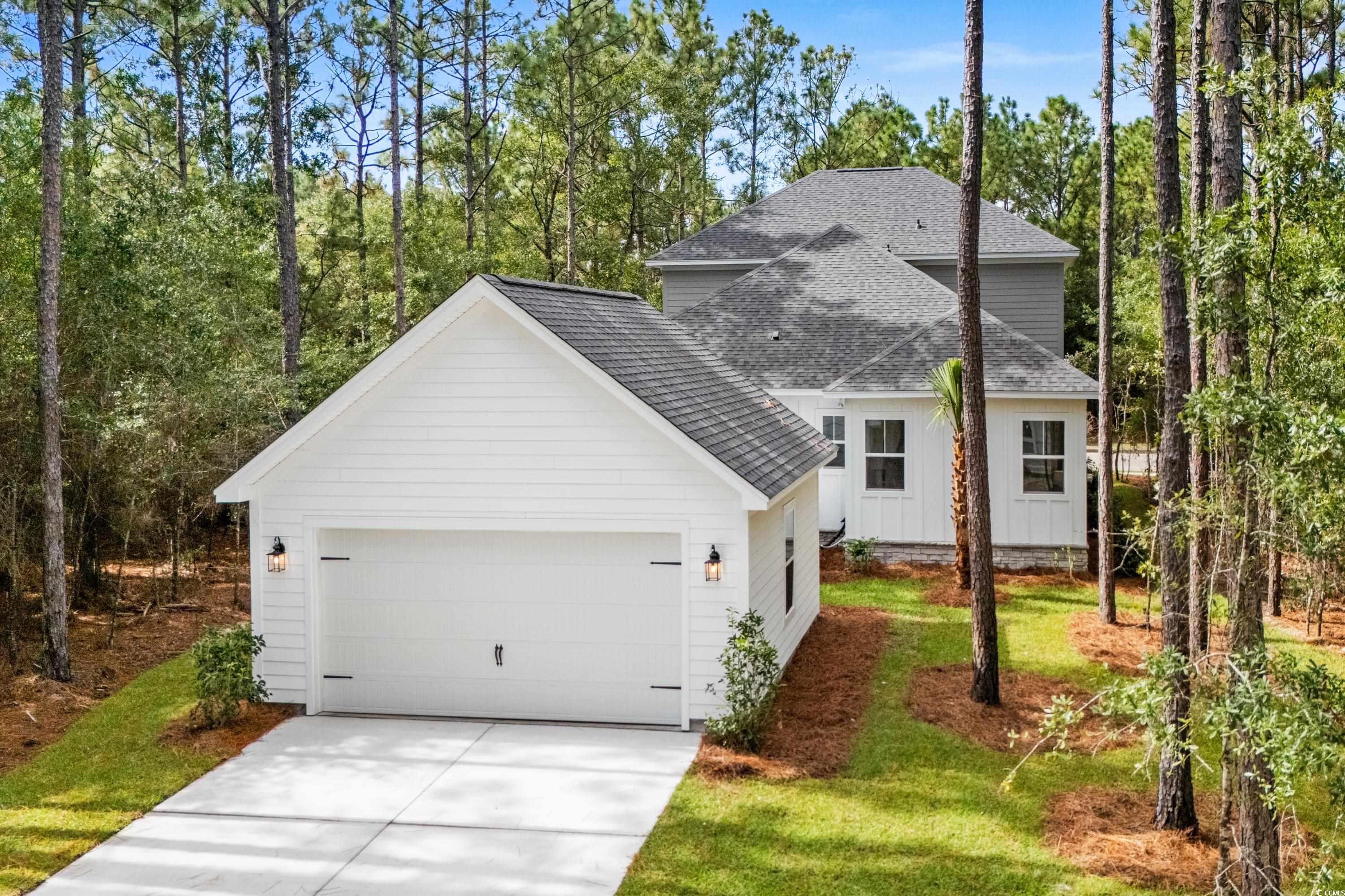 82 Bridge View Road Georgetown, SC 29440 - Photo 26 of 32 View of front of property with roof with shingles, concrete driveway, a garage, board and batten siding, and a front lawn