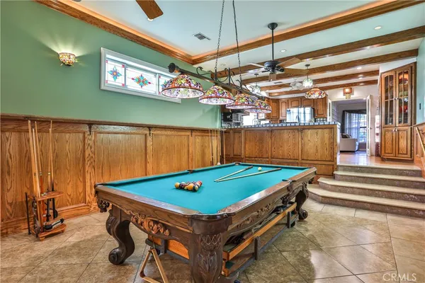 a room with pool table and windows