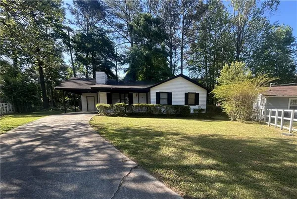 a front view of a house with a yard and trees