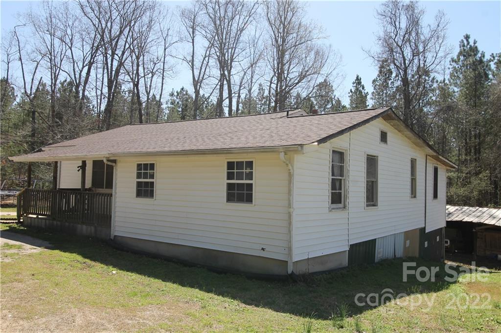 1931 Dan Sexton Road York, SC 29745 - Photo 2 of 22 a view of a white house with a yard and lawn chairs under an umbrella