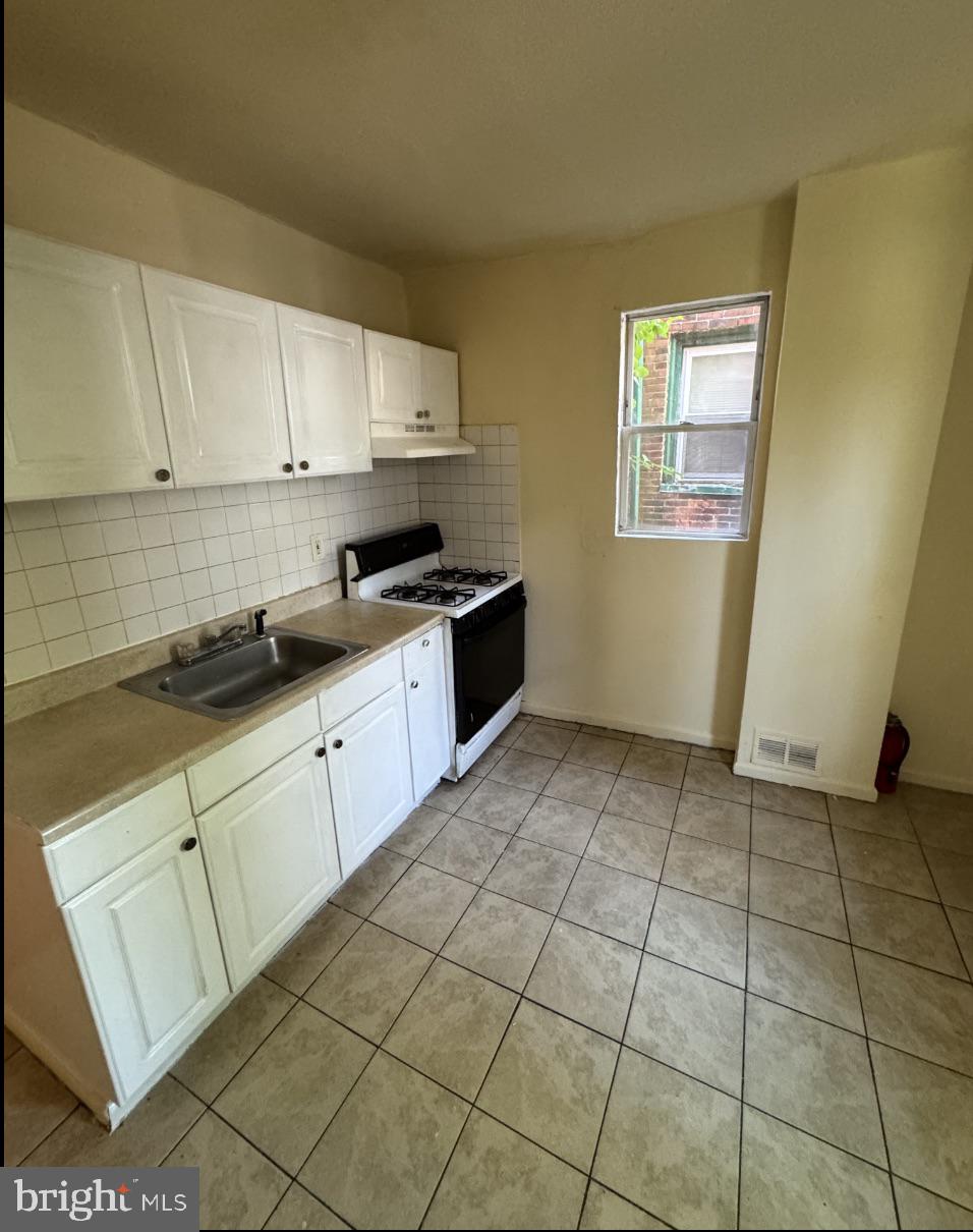 5515 Crowson Street Philadelphia, PA 19144 - Photo 4 of 10 a kitchen with stainless steel appliances a sink and cabinets