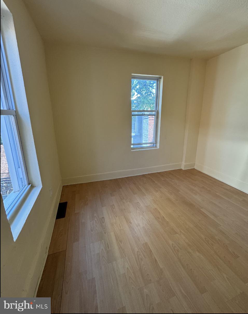5515 Crowson Street Philadelphia, PA 19144 - Photo 9 of 10 an empty room with wooden floor and windows