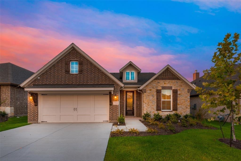a front view of a house with a garden and yard