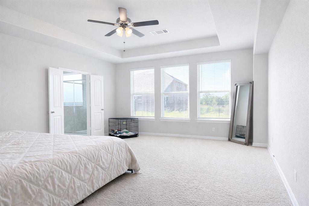 15044 Ted Trail Aledo, TX 76008 - Photo 23 of 37 a spacious bedroom with a large bed and a chandelier