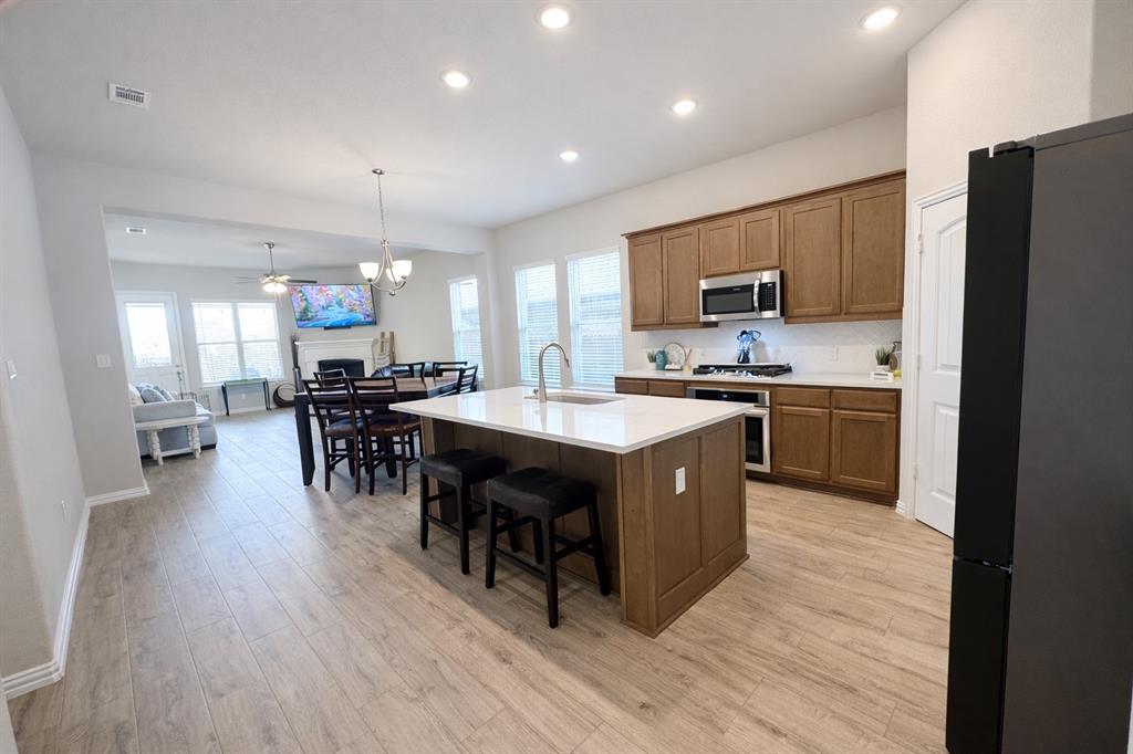 15044 Ted Trail Aledo, TX 76008 - Photo 8 of 37 a kitchen with stainless steel appliances granite countertop a table chairs sink refrigerator and microwave