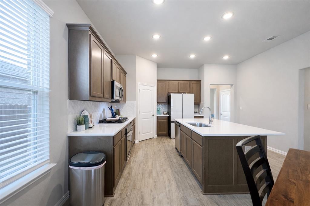 15044 Ted Trail Aledo, TX 76008 - Photo 10 of 37 a kitchen with sink a stove and chairs