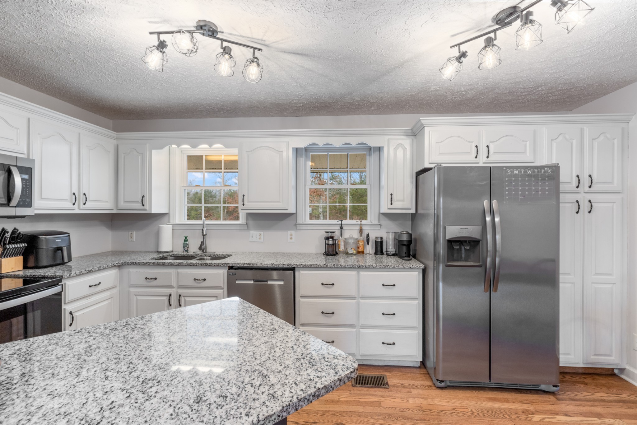 2323 Nubbin Ridge Road Dickson, TN 37055 - Photo 20 of 51 a kitchen with stainless steel appliances granite countertop a refrigerator a sink dishwasher a stove with wooden cabinets and floor