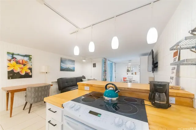 a kitchen with stainless steel appliances granite countertop a stove a sink a dining table and chairs with white cabinets