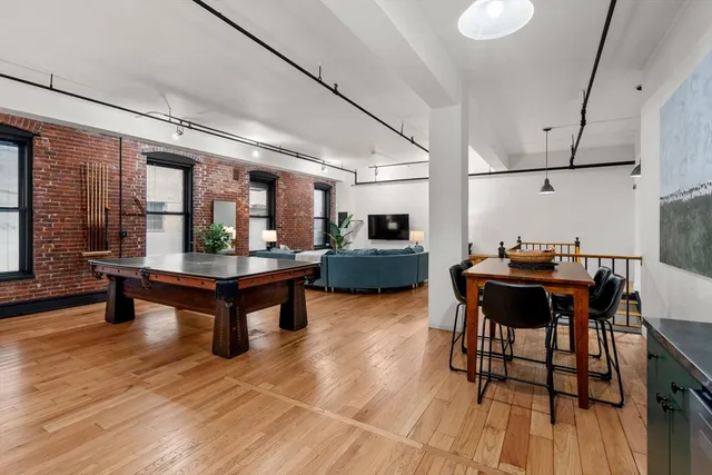 a living room with furniture a wooden floor and next to a window