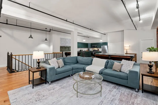 a living room with furniture and a wooden floor