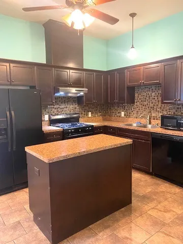 a kitchen with kitchen island cabinets a sink and a stove