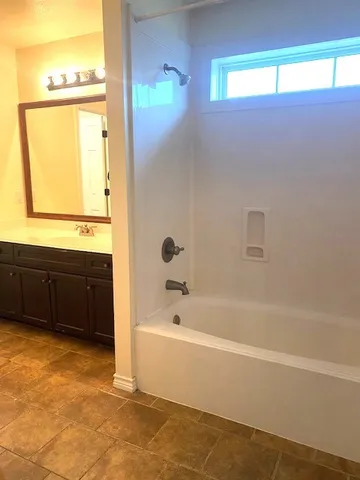 a bathroom with a bathtub and a window