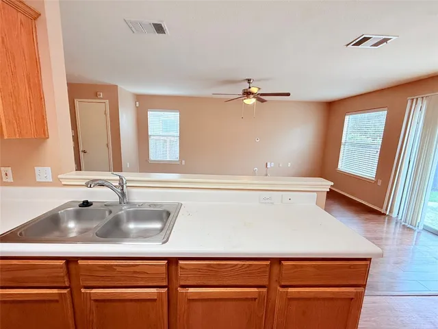 an empty room with windows and a ceiling fan