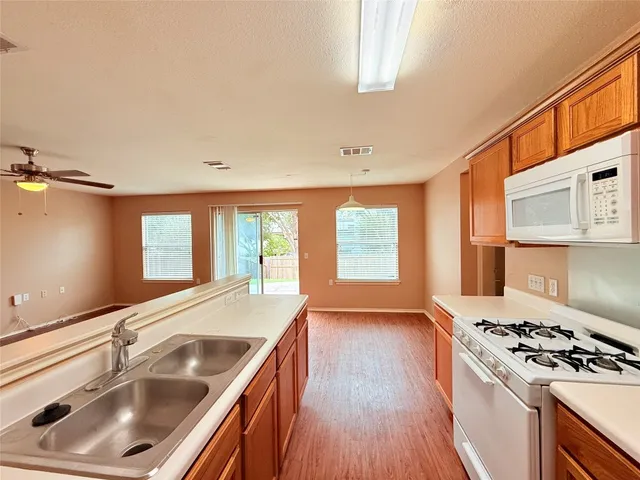 an empty room with windows and ceiling fan