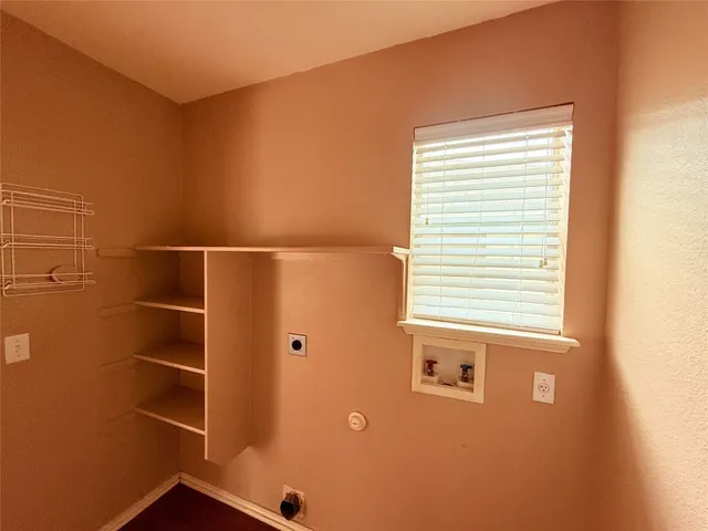 an empty room with windows and chandelier fan