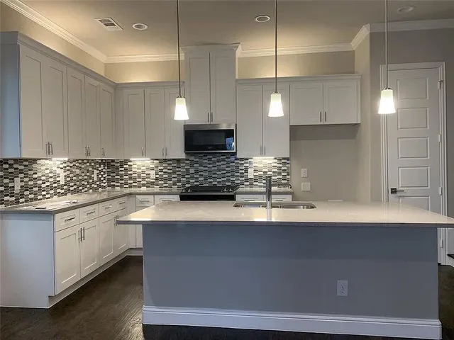 a kitchen with granite countertop a sink a stove and cabinets