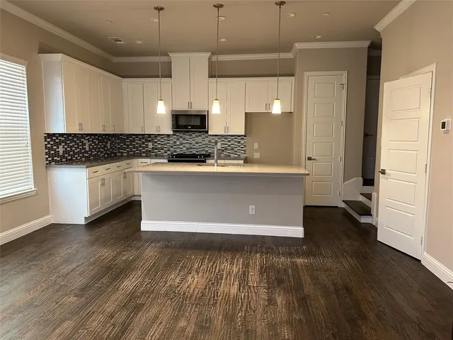 a living room with stainless steel appliances granite countertop a refrigerator a stove and a wooden floors