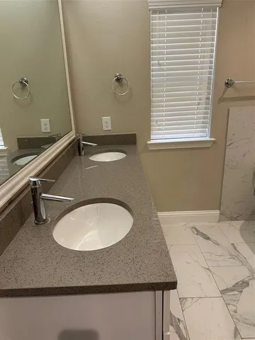 a bathroom with a granite countertop sink a mirror and a window