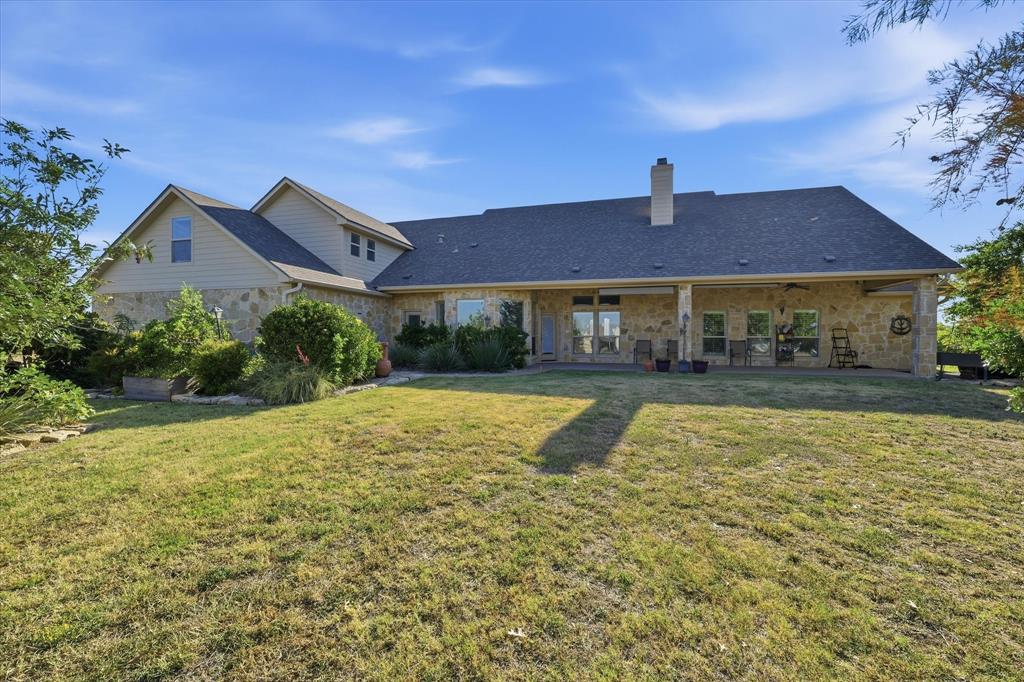 504 Casa Del Rancho Road Lorena, TX 76655 - Photo 36 of 40 Stone exterior with a covered patio, multiple windows, and extensive lawn space