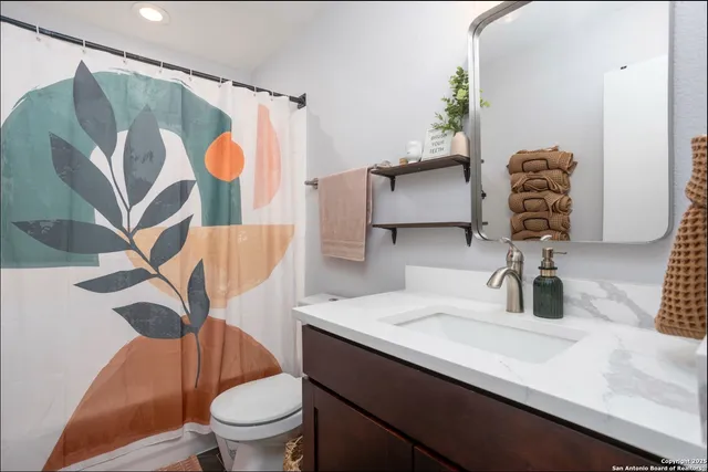 a bathroom with a sink a toilet and shower