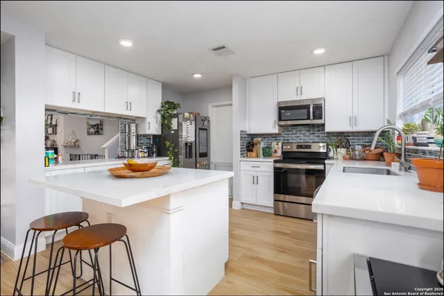 a kitchen with a sink a stove and cabinets