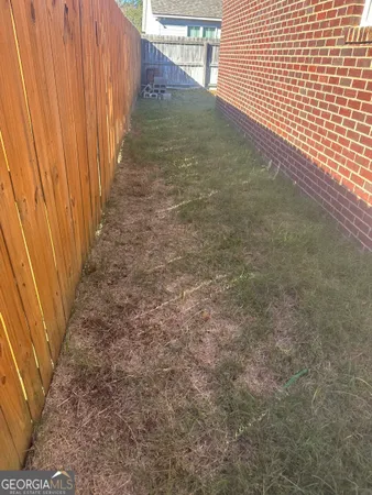 a view of a yard with wooden fence