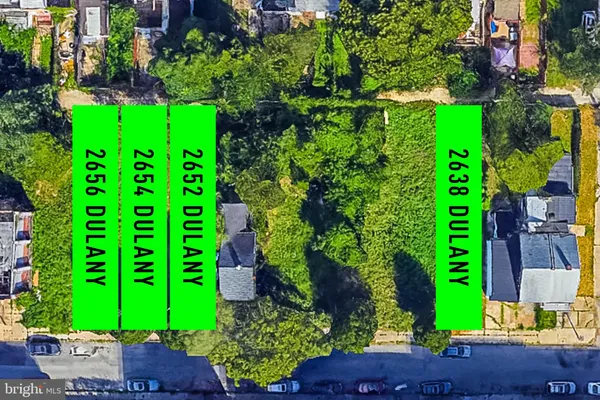 a green field with lots of flowers and trees in the background