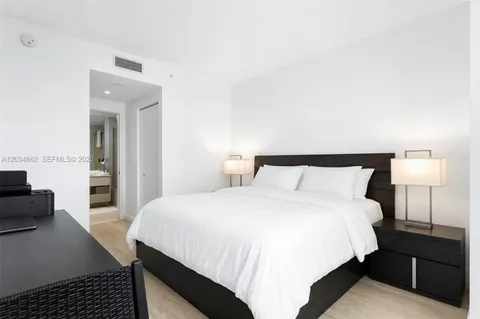 a bedroom with a bed and a lamp