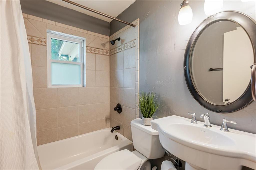 1507 Greenbrier Drive Sherman, TX 75092 - Photo 19 of 27 a bathroom with a sink a bathtub and a mirror