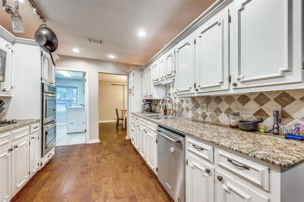 1507 Greenbrier Drive Sherman, TX 75092 - Photo 6 of 27 a large kitchen with stainless steel appliances granite countertop a lot of counter space and wooden floors