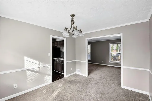 a view of a livingroom with a chandelier fan and windows