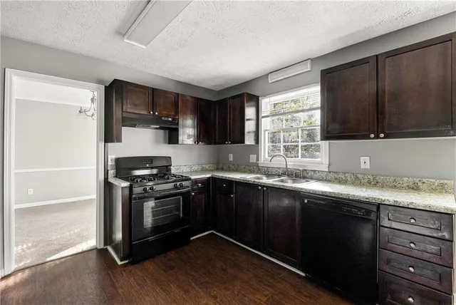 a kitchen with stainless steel appliances wooden cabinets and a stove top oven