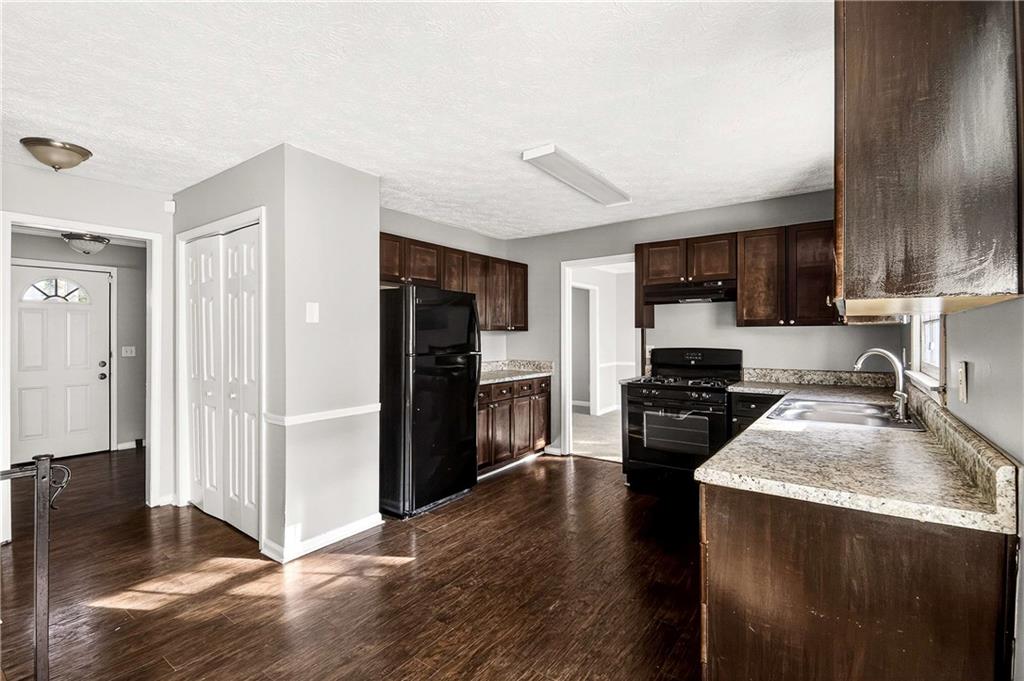 1075 Forest Heights Road Stone Mountain, GA 30083 - Photo 15 of 42 a kitchen with a refrigerator stove and sink