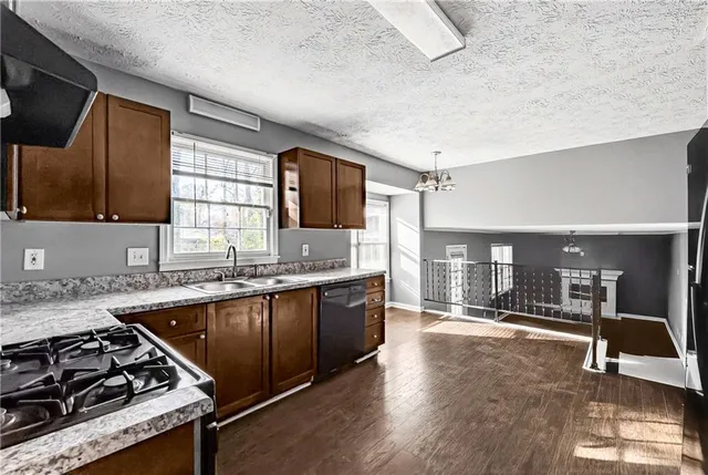 a large kitchen with stainless steel appliances granite countertop a stove and a sink