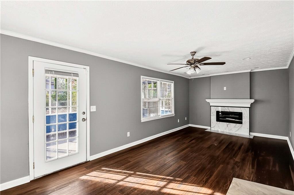 1075 Forest Heights Road Stone Mountain, GA 30083 - Photo 18 of 42 a view of an empty room with wooden floor fireplace and a window