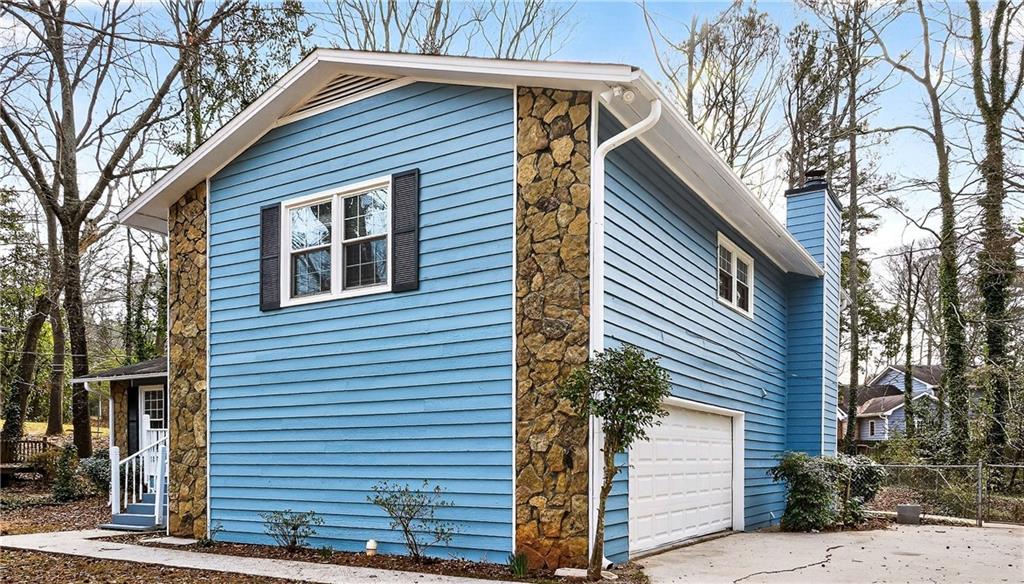 1075 Forest Heights Road Stone Mountain, GA 30083 - Photo 2 of 42 a front view of a house with a tree